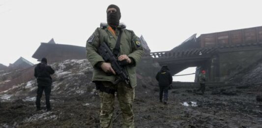 A Ukrainian Serviceman Guards As Emergency Workers Inspect A Damaged Bridge Near Kuznetsovka