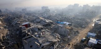 Παλαιστίνιοι περπατούν δίπλα στα ερείπια Gaza