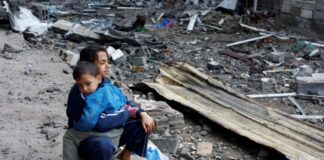 Παλαιστίνια παιδιά κάθονται σε σημείο ισραηλινής επιδρομής Gaza